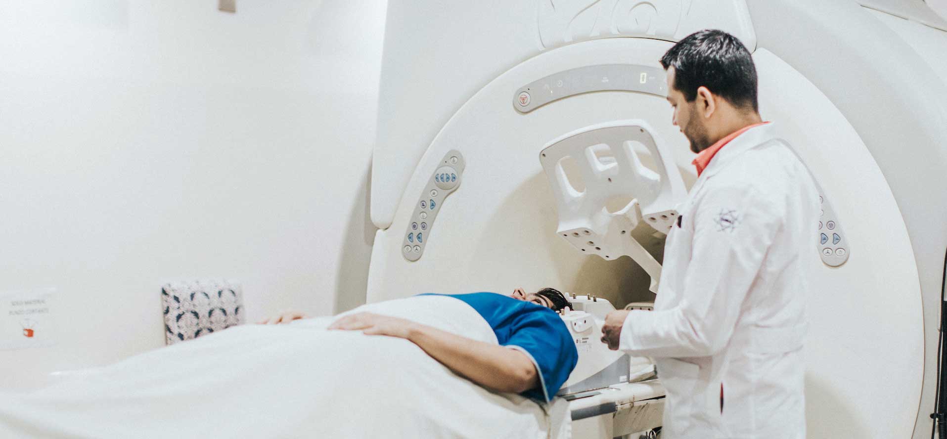 A patient attended by a physician is about to undergo diagnostic imaging.