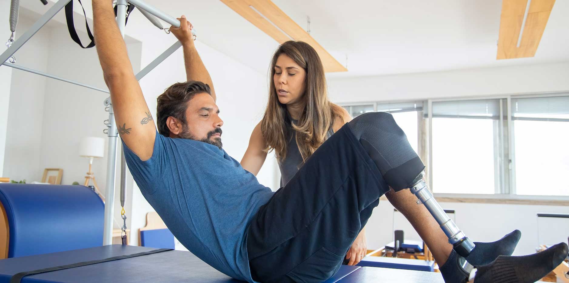 A physiotherapist assists a patient with rehab exercises. 