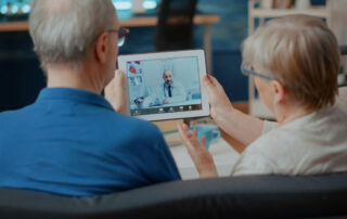 senior couple attending online meeting with doctor