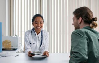 woman doctor talks to male patient