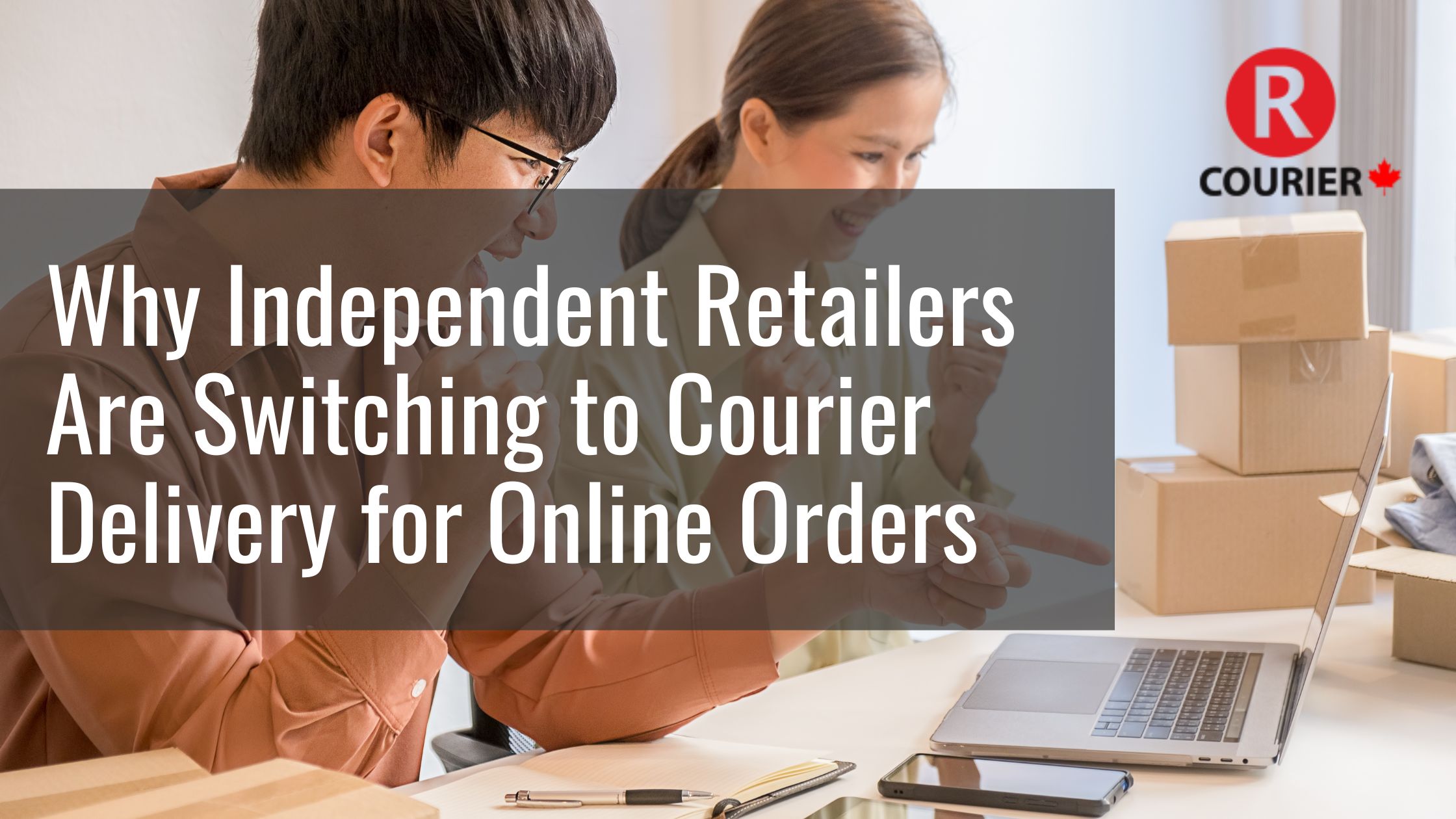 Two small business owners smiling and pointing at a laptop while surrounded by shipping boxes, showing the convenience of courier delivery for online retail orders with R Courier.
